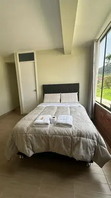 a bedroom with a large bed with towels on it at La Herencia - Oxapampa in Oxapampa