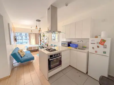 a kitchen with white cabinets and a stove top oven at Departamento exclusivo a un paso de San Isidro in Lima