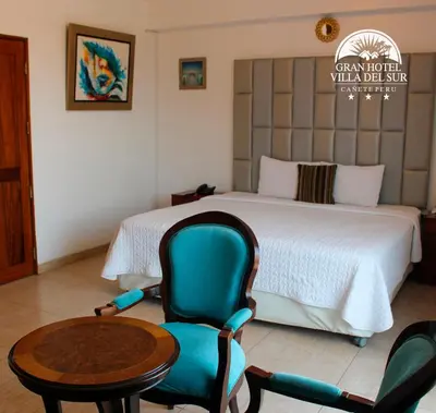 a bedroom with a bed and a chair and a table at GRAN HOTEL VILLA DEL SUR in San Vicente de Cañete