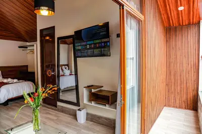 a room with a bed and a vase with flowers at Hotel Tierra Inka Sacred Valley in Ollantaytambo