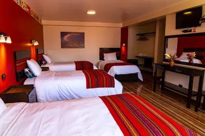 a hotel room with two beds with red walls at Hotel Tierra Inka Sacred Valley in Ollantaytambo