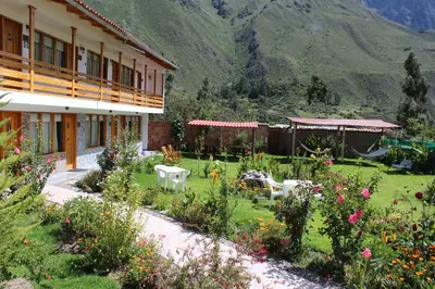 a garden in front of a building with flowers at Hotel Tierra Inka Sacred Valley in Ollantaytambo