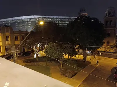 a view of a city at night with a stadium at Quinoa Backpackers Hostel in Lima