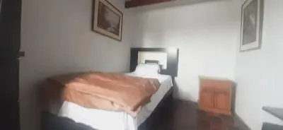 a bedroom with a bed in a white room at Quinoa Backpackers Hostel in Lima
