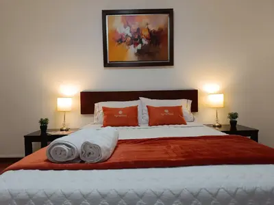 a bedroom with a bed with two pillows and two lamps at Runawasi Apartments - José Gonzales 3BDR, near to Larcomar in Lima