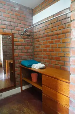 a bathroom with a brick wall and a wooden counter at La Fogata del Sur in Fundo Copacabana