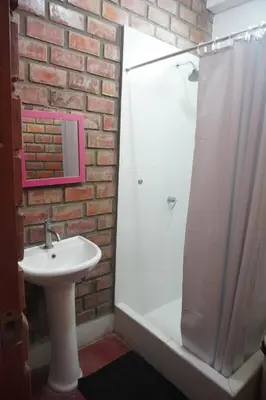 a bathroom with a white sink and a shower at La Fogata del Sur in Fundo Copacabana