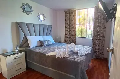 a bedroom with a bed with two swans on it at Mini Apartamento Vista Verde in Lima