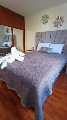 a bedroom with a large bed with towels on it at Mini Apartamento Vista Verde in Lima