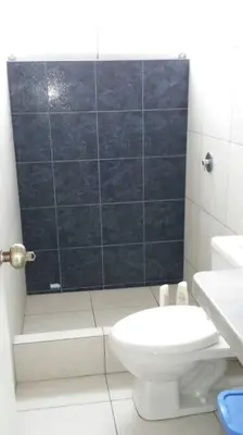a white bathroom with a toilet and a shower at Departamento en playa Chocaya. Disfruta del mar, la piscina y la tranquilidad. in Asia