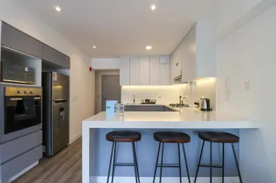 a kitchen with two bar stools at a counter at Alameda by Wynwood House in Lima