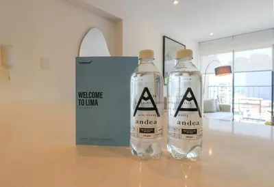 two water bottles sitting on a table with a welcome touador sign at Alameda by Wynwood House in Lima