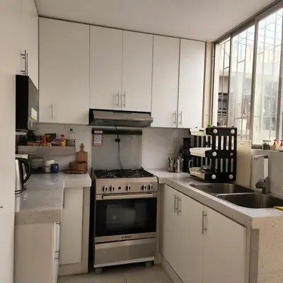 a kitchen with white cabinets and a stove and a sink at CASA CULTURA in Lima