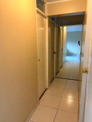 a corridor of a hallway with white tiles at Departamento cerca al boulevard in Lima