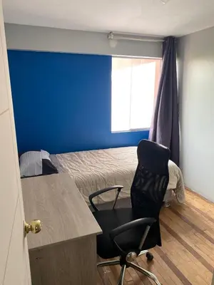 a room with a bed and a desk and a chair at Departamento cerca al boulevard in Lima