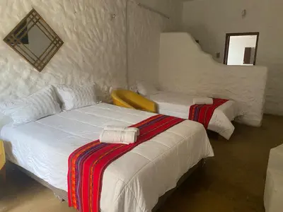 a hotel room with two beds with towels on them at Los Andes - Restaurant & Bungalows in Cieneguilla