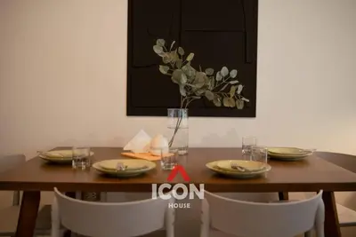 a wooden table with plates and a vase of flowers at Designed Studio in Miraflores / Amazing View in Lima