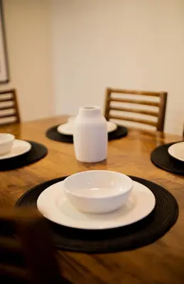 a wooden table with plates and a white bowl on it at Beautiful 2BR in Miraflores in Lima