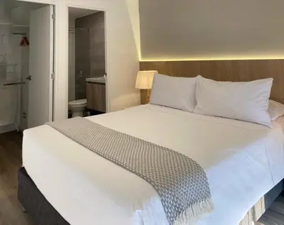 a large white bed in a small room at Los Pinos by Wynwood House in Lima