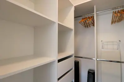 a walk in closet with white cabinets and a refrigerator at Los Pinos by Wynwood House in Lima