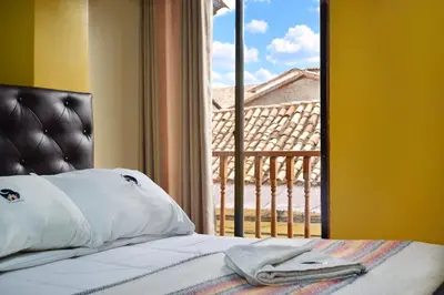 a bedroom with a bed and a window with a view at Killa Anqas - Departamento en el centro del Cusco in Cusco