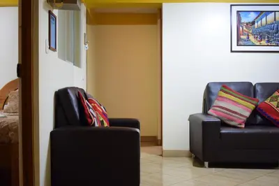 two chairs and a couch in a room at Killa Anqas - Departamento en el centro del Cusco in Cusco