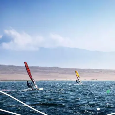 two people windsurfing in the ocean on the water at Relájate en piscina-spa, terraza BBQ y AC Paracas in Paracas