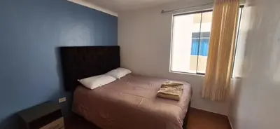 a small bed in a room with a window at Lucia's apartmens in Cusco