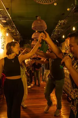 a group of people dancing on a dance floor at Black Llama Hostel Cusco in Cusco