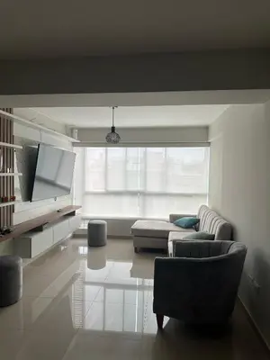 a living room with a couch and a tv at Apartamento 3 habitaciones, Santa Beatriz - Perú in Lima