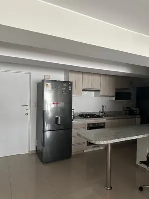 a kitchen with a stainless steel refrigerator and a table at Apartamento 3 habitaciones, Santa Beatriz - Perú in Lima