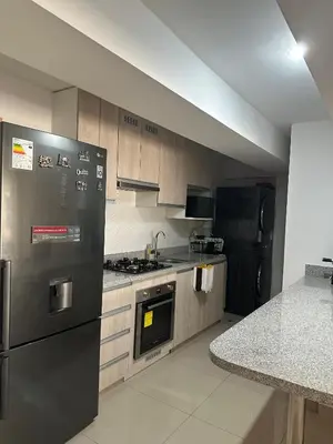 a kitchen with stainless steel appliances and a counter at Apartamento 3 habitaciones, Santa Beatriz - Perú in Lima