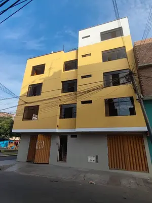 a yellow building on the side of a street at SUMAQ PUNUY HOSTEL - Lima Airport in Lima