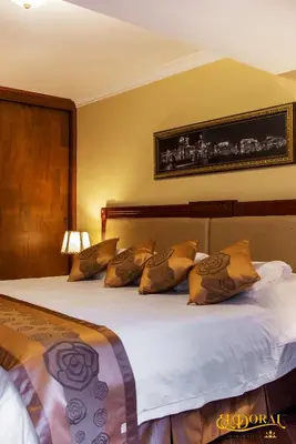 two beds in a hotel room with yellow walls at Apart Hotel El Doral in Lima