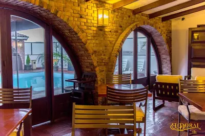 a restaurant with a pool and tables and chairs at Apart Hotel El Doral in Lima