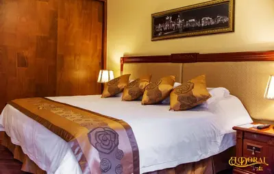 a bedroom with a large bed with yellow pillows at Apart Hotel El Doral in Lima
