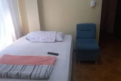 a bedroom with a bed and a blue chair at 202 Comfy Apt WiFi kitchen SmartTV Central at Callao in Lima