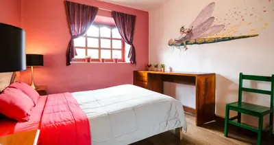 a red bedroom with a bed and a window at Dragonfly Hostels Cusco in Cusco