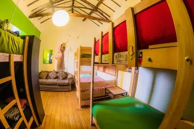 a room with bunk beds and a room with a couch at Dragonfly Hostels Cusco in Cusco