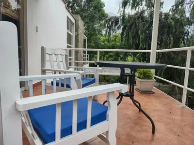 a patio with two chairs and a table on a balcony at Hotel Los Palomos in Lunahuaná