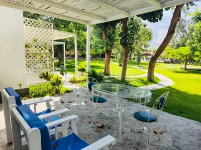a patio with a glass table and chairs at Hotel Los Palomos in Lunahuaná
