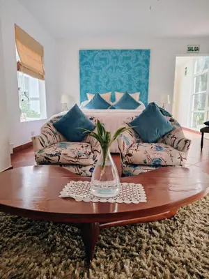 a living room with a couch and a vase on a table at Hotel Los Palomos in Lunahuaná
