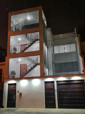 a building with two garage doors and a balcony at Dormitorio matrimonial 01 in Lima