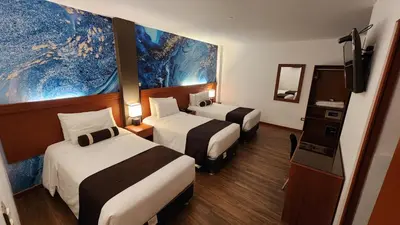 a hotel room with two beds and a tv at Hotel Ferré Machu Picchu in Machu Picchu