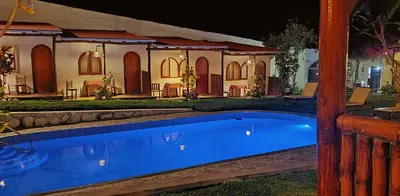 a swimming pool in front of a house at night at La Fortaleza del Inca in Lunahuaná