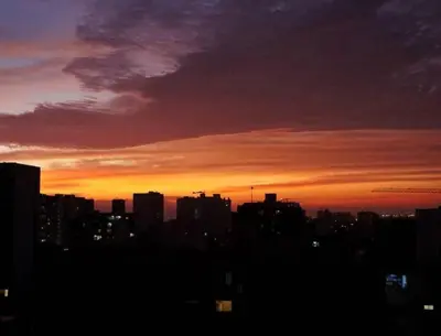 a city skyline with a sunset in the background at Céntrico, acogedor y amplio apartamento en Magdalena in Lima