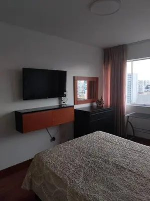 a bedroom with a bed and a flat screen tv at Céntrico, acogedor y amplio apartamento en Magdalena in Lima