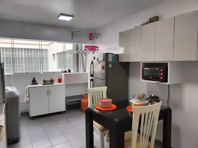 a kitchen with a black table and white cabinets at Céntrico, acogedor y amplio apartamento en Magdalena in Lima