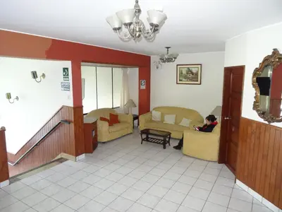 a person sitting on a couch in a living room at Hotel Nova in Lima
