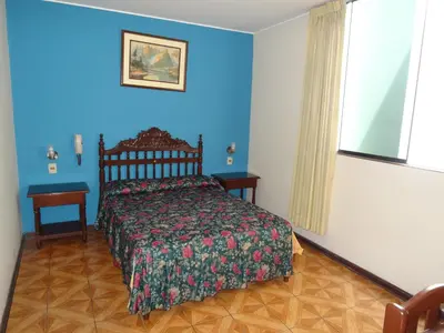 a bedroom with a bed and a blue wall at Hotel Nova in Lima